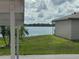 Beautiful backyard with lake view, palm trees, and lush green grass at 344 Winter Ridge Blvd # 344, Winter Haven, FL 33881