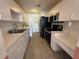Functional kitchen with white cabinetry, black appliances, and tiled flooring at 344 Winter Ridge Blvd # 344, Winter Haven, FL 33881