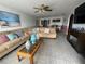Spacious living room featuring tile floors, a large sofa and view into the dining area at 344 Winter Ridge Blvd # 344, Winter Haven, FL 33881