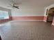 Open living space featuring tile floors, a ceiling fan, and an archway leading to the kitchen at 344 Winter Ridge Blvd # 344, Winter Haven, FL 33881