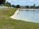 View of backyard with white sand beach on lake with wildlife and grass at 3638 Doe Run Dr, St Cloud, FL 34772