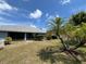 Lush backyard featuring well-kept landscaping, a screened-in patio, and decorative palm trees at 3638 Doe Run Dr, St Cloud, FL 34772