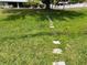 Lush backyard featuring a stone pathway, mature trees, and a well-maintained lawn on a sunny day at 3638 Doe Run Dr, St Cloud, FL 34772