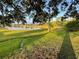 Tranquil backyard view with lush greenery leading to a serene pond reflecting sky at 3638 Doe Run Dr, St Cloud, FL 34772