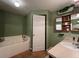 Bathroom featuring a soaking tub, vanity with sink, and a decorative mirror for added elegance at 3638 Doe Run Dr, St Cloud, FL 34772