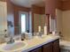 Bathroom featuring a double vanity, bathtub, and an exit door, offering functionality and natural light at 3638 Doe Run Dr, St Cloud, FL 34772