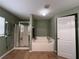 Clean bathroom featuring a soaking tub, glass-enclosed shower, and a door for easy access and ventilation at 3638 Doe Run Dr, St Cloud, FL 34772