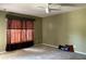 Spacious bedroom featuring a ceiling fan, plush carpeting, and large windows adorned with decorative curtains at 3638 Doe Run Dr, St Cloud, FL 34772