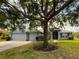 Charming single Gathering home featuring a light blue exterior and well manicured lawn with mature shade tree at 3638 Doe Run Dr, St Cloud, FL 34772
