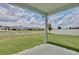 View from covered back patio looking out to the pond and neighboring homes at 4327 Silver Creek St, Kissimmee, FL 34744