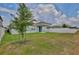 A view of the home and patio from the backyard, with a privacy fence and young trees at 4327 Silver Creek St, Kissimmee, FL 34744