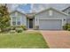 Charming single-story home with a brick driveway, stone accents, and lush landscaping at 4327 Silver Creek St, Kissimmee, FL 34744
