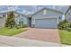 Attractive single-story home displaying a blue exterior, brick driveway, and well-maintained landscaping at 4327 Silver Creek St, Kissimmee, FL 34744