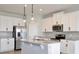 Modern kitchen boasts white cabinets, stainless steel appliances, granite countertops, and pendant lighting at 4327 Silver Creek St, Kissimmee, FL 34744