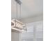 Close up on farmhouse kitchen light fixture over window with white shutters at 4327 Silver Creek St, Kissimmee, FL 34744