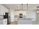 Modern kitchen boasts white cabinets, stainless steel appliances, granite countertops, and pendant lighting at 4327 Silver Creek St, Kissimmee, FL 34744