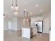 Open-concept living space features stylish pendant lighting, white cabinets, and stainless steel appliances at 4327 Silver Creek St, Kissimmee, FL 34744