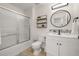 Modern bathroom features a bathtub with shower, decorative floating shelves and a large round mirror at 4722 Flagler Beach Way, Kissimmee, FL 34746
