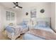 Well-lit bedroom featuring two twin beds, artwork, and wood-look flooring at 4722 Flagler Beach Way, Kissimmee, FL 34746