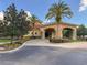 Clubhouse entrance with a covered portico, palm trees, and a well-manicured driveway at 4722 Flagler Beach Way, Kissimmee, FL 34746