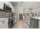 Bright kitchen with white cabinetry, stainless steel appliances, and modern countertops overlooking the living area at 4722 Flagler Beach Way, Kissimmee, FL 34746