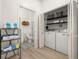 Bright laundry area with white appliances, storage shelves, and adjacent bathroom entrance at 4722 Flagler Beach Way, Kissimmee, FL 34746