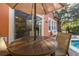 Cozy outdoor seating area beneath a large umbrella, overlooking a pool and lush backyard at 4722 Flagler Beach Way, Kissimmee, FL 34746
