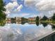 Scenic view of pond reflecting community homes, trees and sky at 4722 Flagler Beach Way, Kissimmee, FL 34746