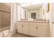 A spacious bathroom featuring a double vanity, large mirror, and bathtub with shower at 4835 Memories Ln, Kissimmee, FL 34746