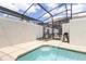 Relax by the pool in this screened enclosure, featuring lounge chairs and a grill for outdoor enjoyment at 4835 Memories Ln, Kissimmee, FL 34746