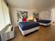 Bright bedroom featuring two beds with blue covers, bamboo art, and laminate floors at 5245 W Irlo Bronson Memorial Hwy # 210, Kissimmee, FL 34746