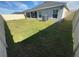 Spacious backyard with lush green lawn, screened porch, and a well-maintained fence at 561 Vittorio Dr, Winter Haven, FL 33884