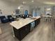 Open-concept kitchen boasts a large island, stainless steel appliances, and views of the living and dining areas at 561 Vittorio Dr, Winter Haven, FL 33884