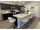 Modern kitchen features dark cabinetry, stainless steel appliances, and a large island with seating at 561 Vittorio Dr, Winter Haven, FL 33884
