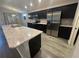 Modern kitchen with dark cabinets, stainless steel appliances, light countertops, and a large kitchen island at 561 Vittorio Dr, Winter Haven, FL 33884