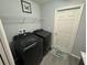Functional laundry room with modern black washer and dryer, plus convenient storage shelves above at 561 Vittorio Dr, Winter Haven, FL 33884