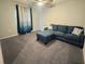 Comfortable living room featuring a plush blue sectional sofa and neutral walls and carpeting at 561 Vittorio Dr, Winter Haven, FL 33884