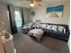 Cozy living room features a plush blue sectional sofa, chair, ottoman, and neutral walls and carpeting at 561 Vittorio Dr, Winter Haven, FL 33884