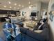 Open-concept living space with kitchen, living room with blue sofas and decor, and a vaulted ceiling at 561 Vittorio Dr, Winter Haven, FL 33884
