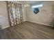Empty room featuring gray walls, modern light fixture, hardwood floors, and large windows with decorative curtains at 561 Vittorio Dr, Winter Haven, FL 33884