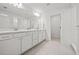 Bright bathroom with double sinks, white cabinets, a large mirror, and sleek, modern finishes at 6019 Forest Perch Dr, St Cloud, FL 34771