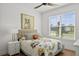 Bright bedroom with a ceiling fan, colorful bedding and a large window offering views of the neighborhood at 6019 Forest Perch Dr, St Cloud, FL 34771