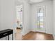 Inviting foyer featuring a decorative glass front door and wood-look flooring leading into a bedroom with a ceiling fan at 6019 Forest Perch Dr, St Cloud, FL 34771