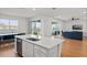Open-concept kitchen overlooking the living area with lake views, a kitchen island, and stainless steel appliances at 6019 Forest Perch Dr, St Cloud, FL 34771