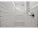 Modern walk-in shower featuring white subway tile, a built-in bench, and a sleek shower head at 6019 Forest Perch Dr, St Cloud, FL 34771
