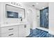 Modern bathroom with a large mirror, sleek vanity, and stylish blue tile shower at 650 Mesilla Dr, Kissimmee, FL 34758