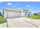 Charming single-Gathering home features a two-car garage, white stucco exterior, and well-maintained landscaping at 650 Mesilla Dr, Kissimmee, FL 34758