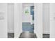 Hallway view into bathroom featuring stylish tile flooring and accent wall, white walls, and modern fixtures at 650 Mesilla Dr, Kissimmee, FL 34758