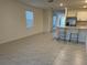 Bright living space featuring tiled floors and a view of the kitchen area with barstool seating at 6783 Grace Hammock Rd, Harmony, FL 34773