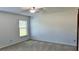 Bedroom featuring plush carpet, neutral paint scheme, ceiling fan, and a large window at 804 Wildwood Cir, Port Orange, FL 32127